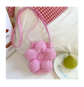 Dettaglio borsa a tracolla a forma di fiore con motivo a quadretti rosa su lino bianco