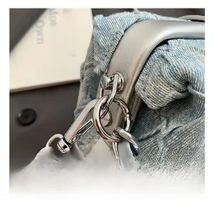 Detailed close-up of premium silver metal hardware on a blue denim shoulder bag