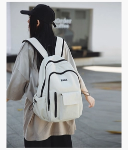 Close-up of modern white backpack with black zippers and drawstring side pocket
