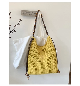 Detail of yellow hand-crochet tote bag with wooden beads and dark leather drawstring