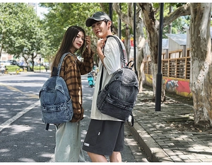 Outdoor shot of vintage light blue and charcoal grey washed denim backpacks for travel