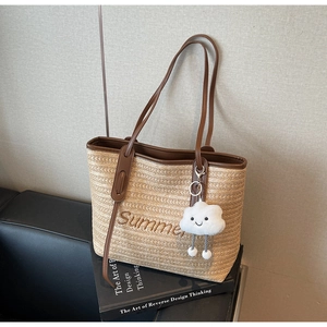 Détail d'un sac cabas en paille tissé main avec broderie Summer et breloque nuage