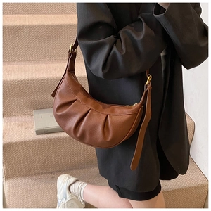 Gros plan d'un sac sous le bras marron en forme de croissant avec texture litchi plissée