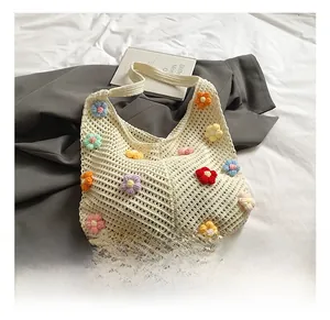 Détail du sac fourre-tout au crochet crème avec fleurs 3D et texture en maille ajourée