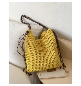 Détail du sac cabas en crochet jaune montrant la maille et les perles en bois vintage