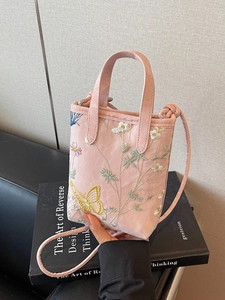 Sac cabas rose avec broderie florale et papillon 3D sur des livres vintage
