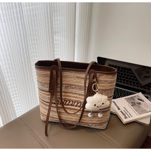 Détail du sac cabas en paille tissé main avec broderie et charm nuage blanc