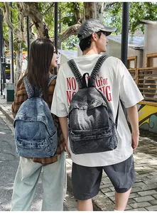 Detailed outdoor view of two vintage denim backpacks in light blue and dark grey denim