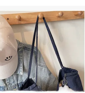 Detail of durable denim tote shoulder strap hanging on a wooden wall hook