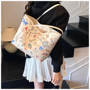 Détail du sac fourre-tout blanc cassé avec imprimés graffiti colorés et fines bretelles