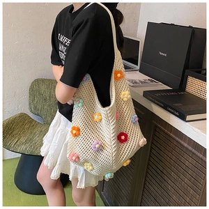 Détail du sac fourre-tout au crochet avec fleurs 3D colorées sur tricot de coton beige