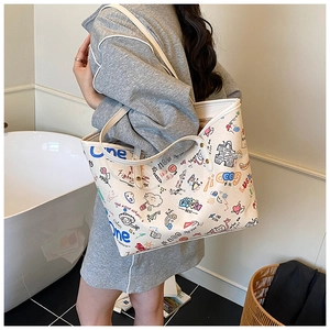 Detailed view of tote bag featuring colorful graffiti prints and white leather straps