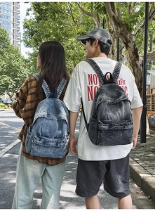Outdoor shot of vintage blue and charcoal denim backpacks set for school or travel
