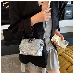 Detail of silver mirror and light blue pleated fabric crossbody bag with metal chain