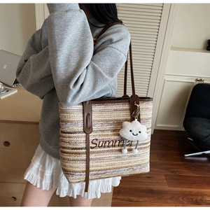 Détail du cabas en paille tissé main avec bandoulière en cuir et broderie Summer