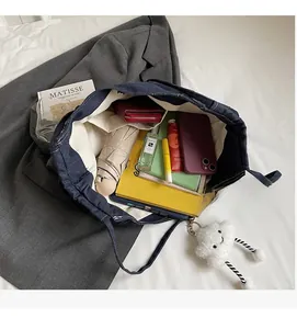 Interior view showing the large capacity and storage compartments of the denim tote bag
