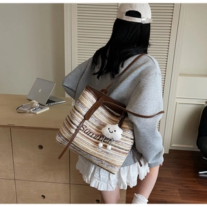 Détail d'un grand sac cabas en paille avec anses en cuir marron et broderie Summer