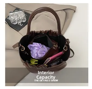Detail showing high-capacity interior of dark brown leather cloud bag with everyday items