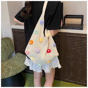 Détail d'un sac fourre-tout ajouré tricoté main avec broderies florales colorées et sangle