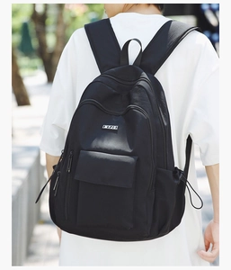 Close-up of black casual backpack featuring drawstring side pockets and logo detail