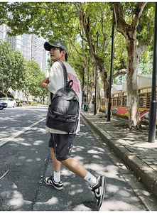 Outdoor shot of a man wearing a large vintage dark grey washed denim backpack for travel
