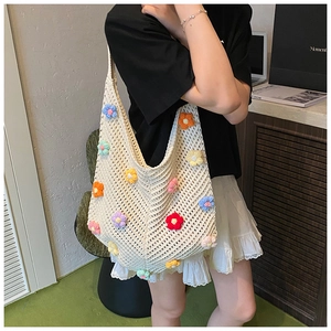 Gros plan d'un sac cabas en tricot crème avec fleurs au crochet 3D et bandoulière