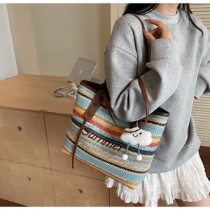 Détail d'un sac cabas tissé à rayures colorées avec broderie Summer et gris-gris nuage