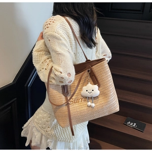 Détail du sac cabas en paille tissé avec broderie Summer et breloque nuage blanc