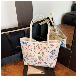 Détail d'un sac cabas en PU blanc avec graffitis colorés sur un sol en bois