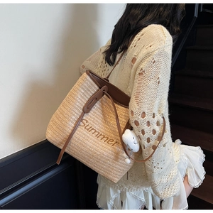 Détail du sac cabas en paille tissé à la main avec broderie Summer et breloque nuage