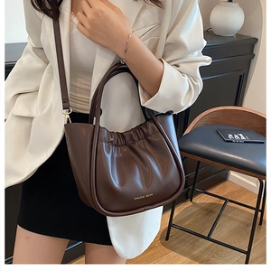 Detailed view of dark brown cloud pleats and logo on premium matte leather bag