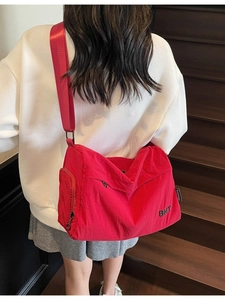 Red durable nylon crossbody messenger bag with side mesh pocket and wide strap