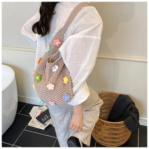 Détail du sac cabas au crochet à la main avec fleurs 3D colorées et texture en tricot ajouré