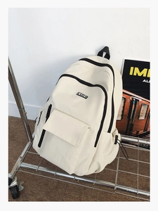 Detail of minimalist canvas backpack with black zipper on silver metal cart