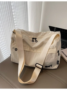 Minimalist cream nylon crossbody bag with black BNT logo and adjustable shoulder strap