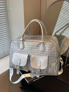 Metallic silver woven travel bag with Intrecciato texture and adjustable shoulder strap