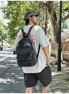 Outdoor street shot of a vintage charcoal denim backpack with large capacity
