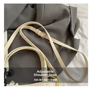 Détail de la bandoulière réglable avec boucle argentée sur le sac fourre-tout beige
