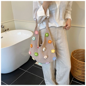 Détail d'un sac cabas tricoté à la main avec fleurs 3D au crochet dans une salle de bain