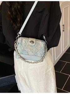 Elegant light blue quilted crossbody bag with silver chain strap and metal clasp closure