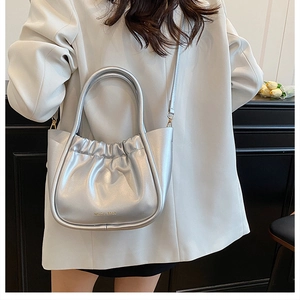 Silver pleated bucket bag featuring metallic PU texture and a structured round handle