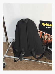 Rear view of black minimalist backpack showing padded straps and elastic side pockets