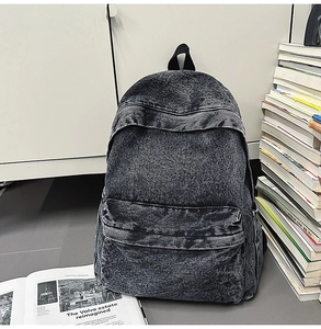 Detailed view of retro washed grey denim backpack with front pocket in a lifestyle setting
