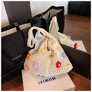 Gros plan d'un sac cabas en tricot ajouré avec détails de fleurs au crochet colorées