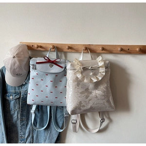 Detail of sweet bow prints and ruffle edges on stylish college style backpacks