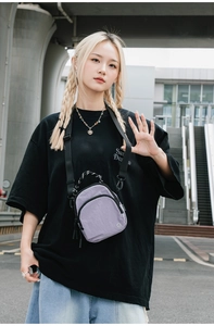 Gros plan d'un petit sac bandoulière en nylon lavande imperméable avec poignées tissées