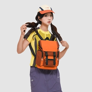 Detail of outdoor backpack with orange contrast panels and dual buckle flap closure