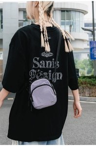 Détail d'un sac bandoulière en nylon violet clair porté au dos avec bandoulière réglable