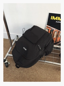 Detail of black heavy-duty nylon backpack with multiple compartments and MYJC brand label