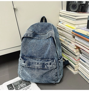 Detail view of retro blue denim backpack with zipper pockets and vintage props background